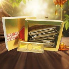 Gold packaging with honeycomb design and honey drizzling, on a wooden surface.