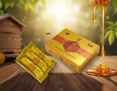 Yellow VIP honey product packaging with honeycomb design on a wooden surface with honey and a beehive in the background.